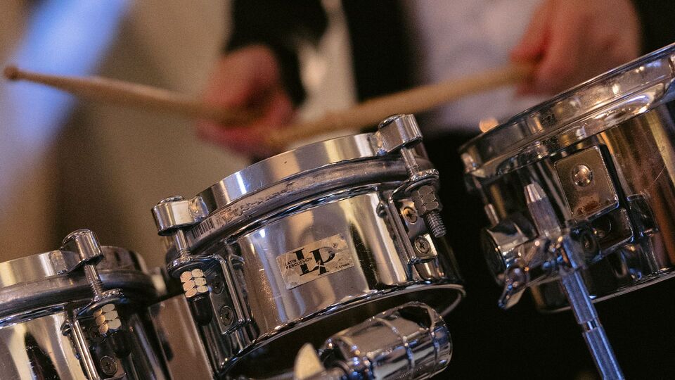 Drumsticks over chrome tom drums, close up