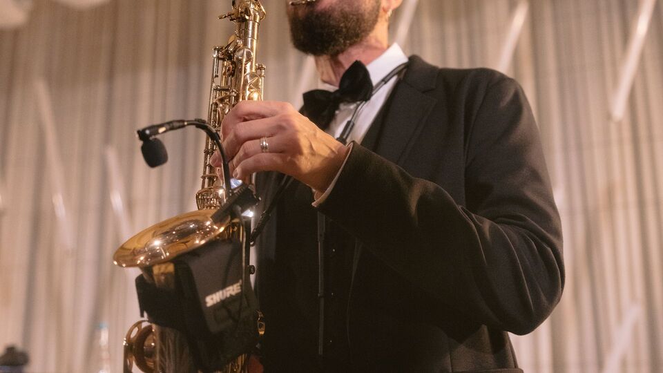 Saxophonist in a tuxedo with a clip-on microphone on his saxophone