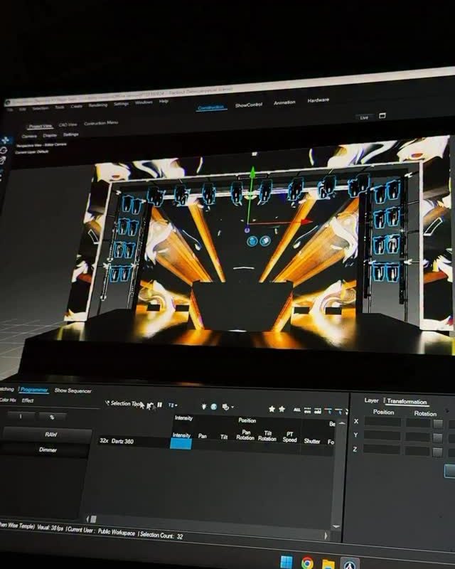 A laptop running lighting-design software, showing a 3D model of a stage and LED wall