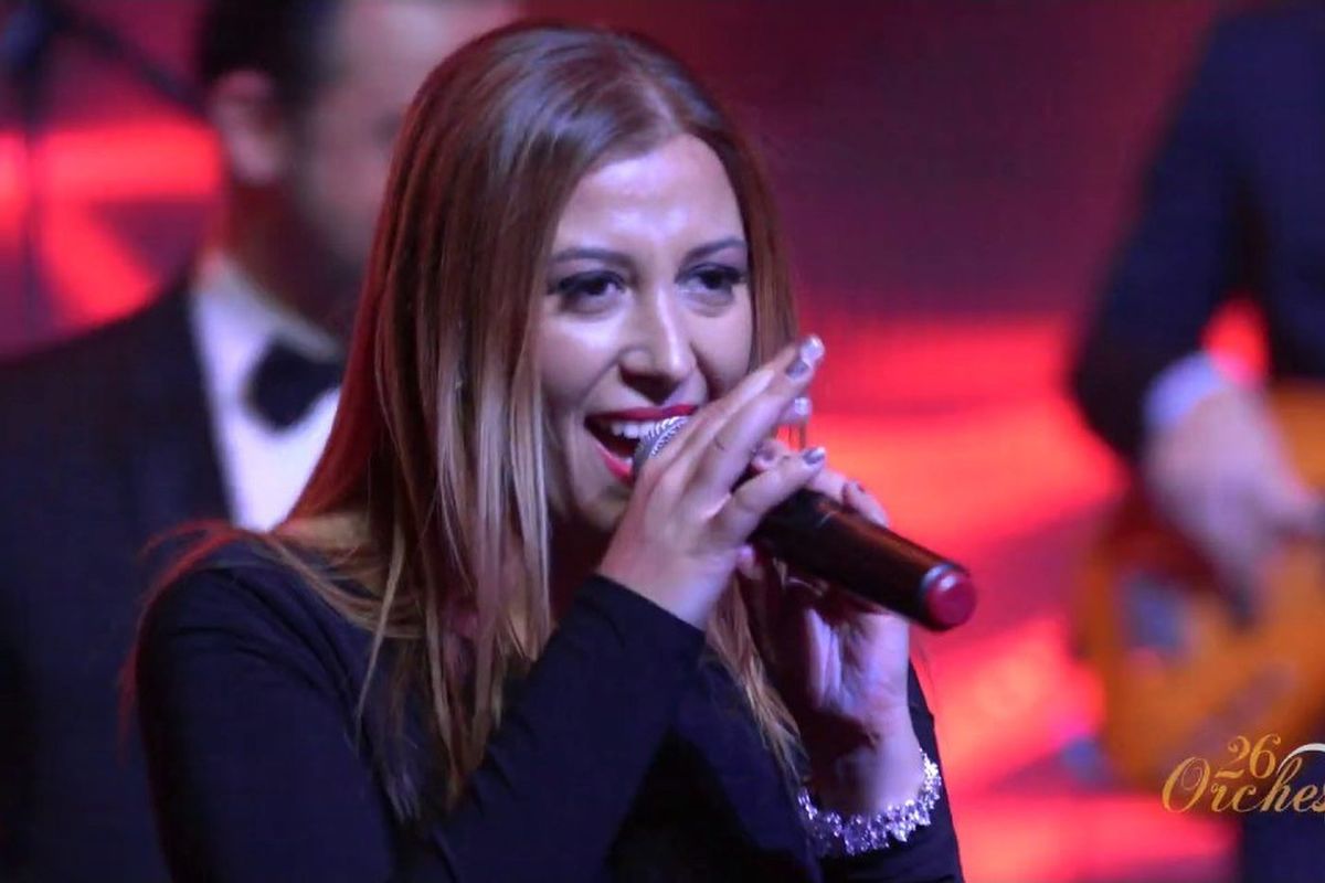 26 Orchestra's vocalist performing under red stage light