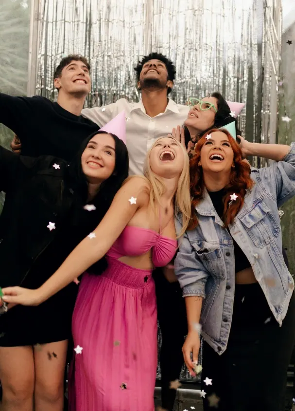 Friends celebrating under falling confetti at a party