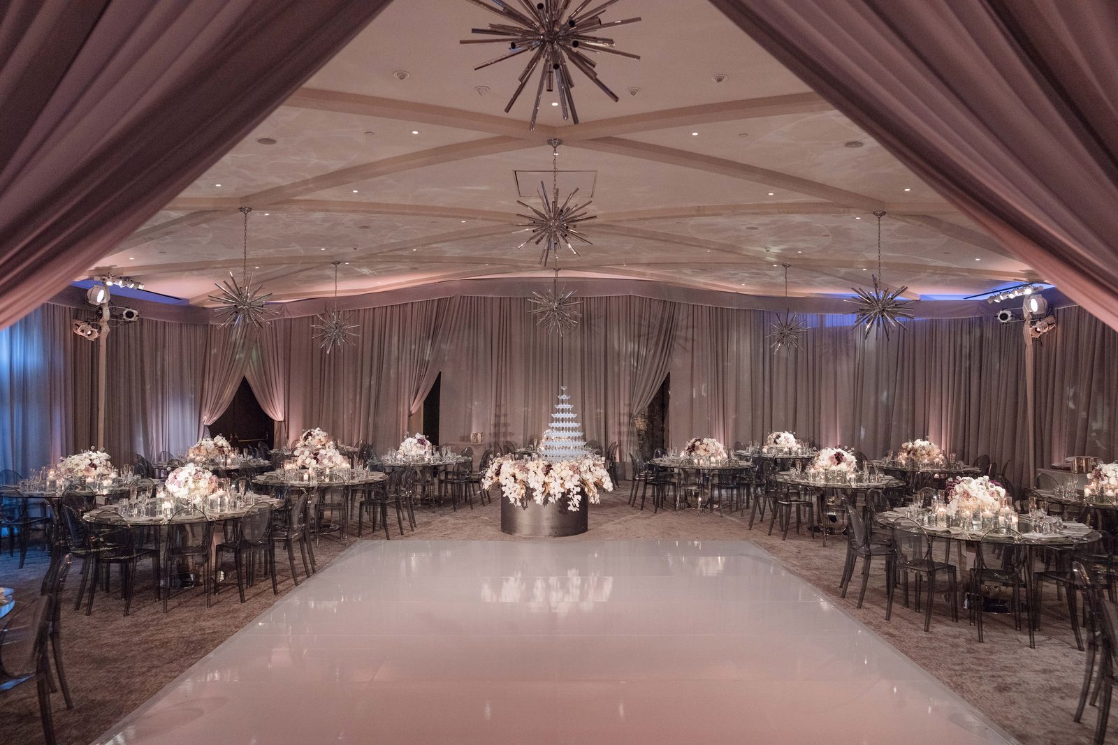 Draped ballroom at Hotel Bel-Air set with mirrored tables and a white dance floor running to a tiered cake