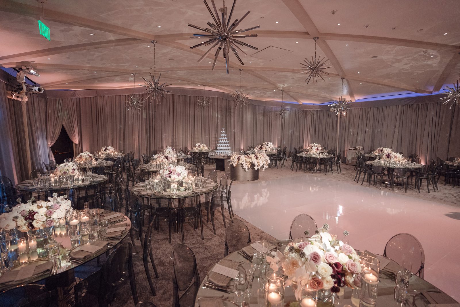 Angled view of the Hotel Bel-Air ballroom showing the vaulted beamed ceiling, cake table and empty dance floor