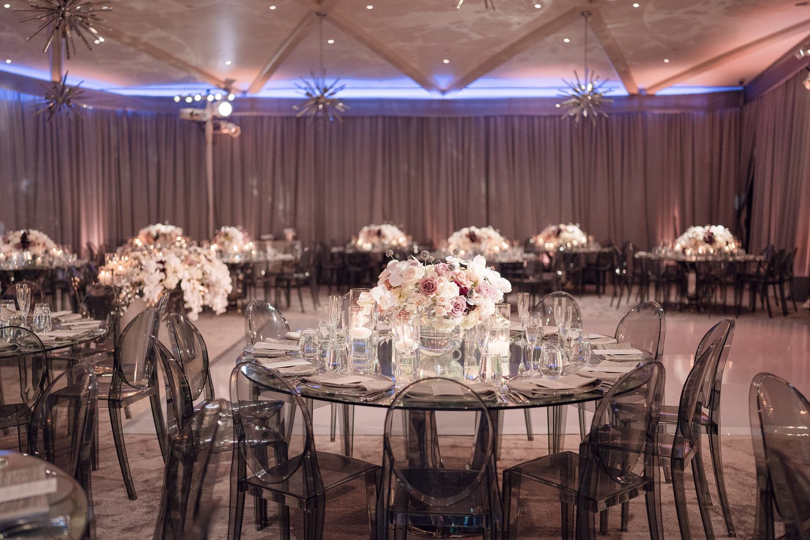 Mirrored dinner tables with orchid centrepieces at Hotel Bel-Air under blush and blue uplighting