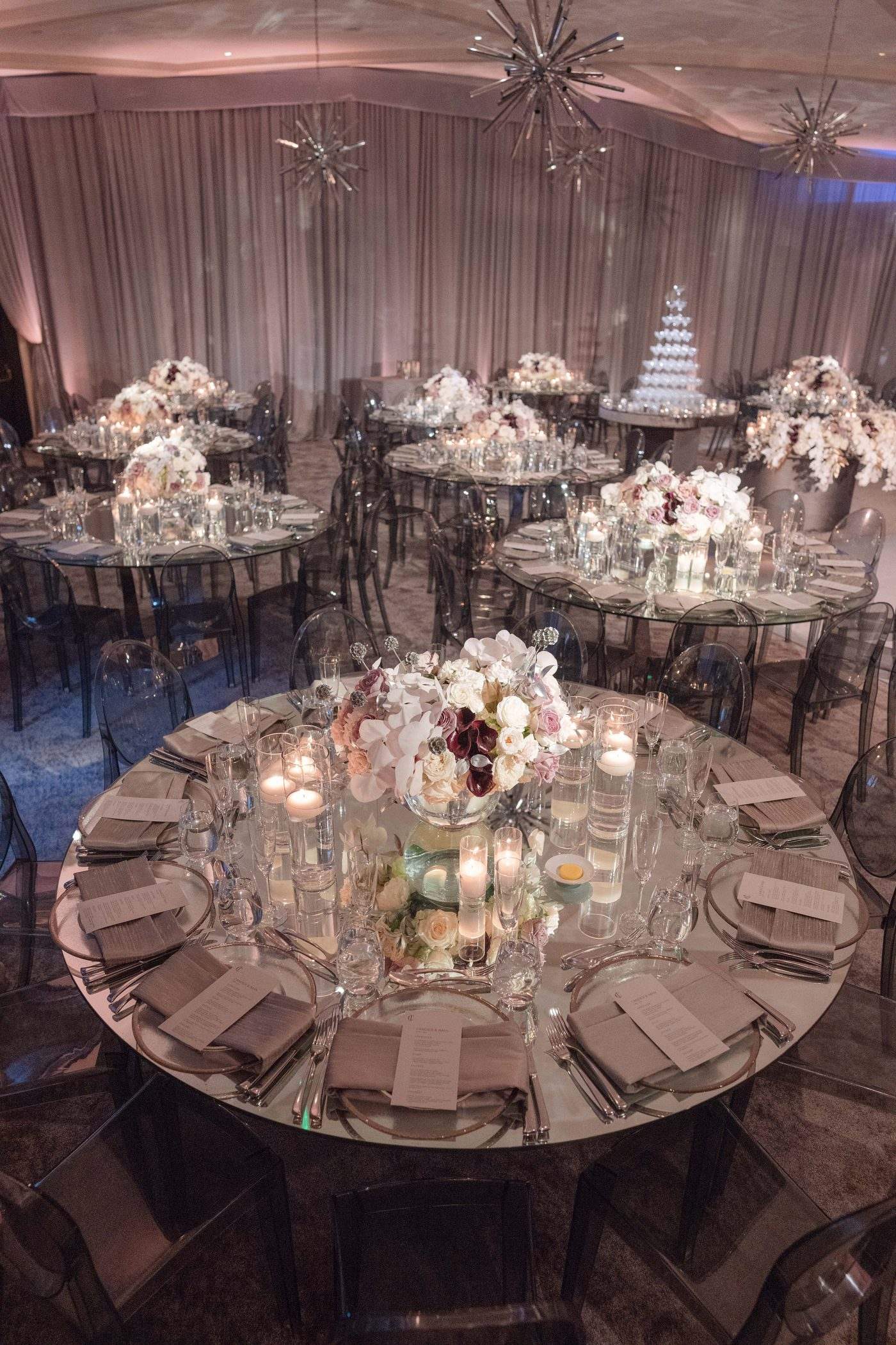 Close view of a mirrored table at Hotel Bel-Air with menus, floating candles and an orchid and rose centrepiece