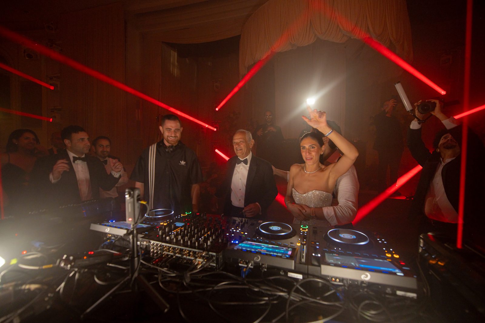 Red beam lighting fanning across the Beverly Wilshire ballroom above a LIV Entertainment DJ booth