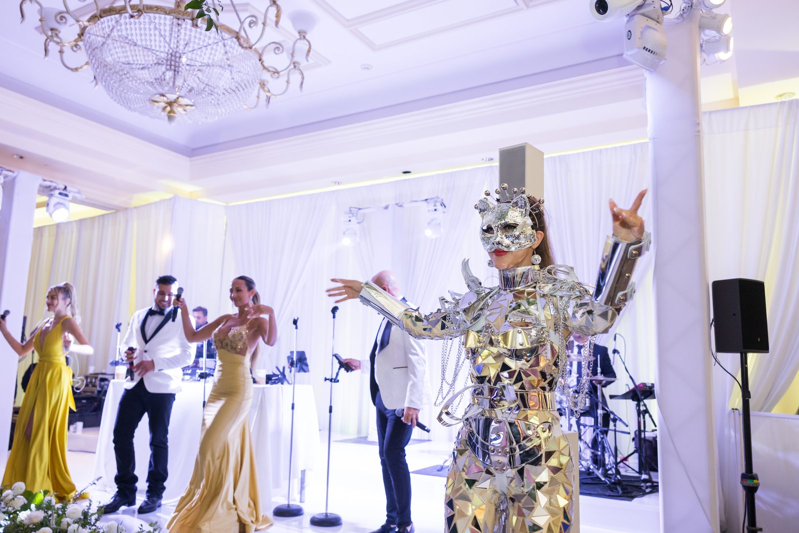 Performer in a mirrored costume and mask standing in front of the live band at Waldorf Astoria Monarch Beach